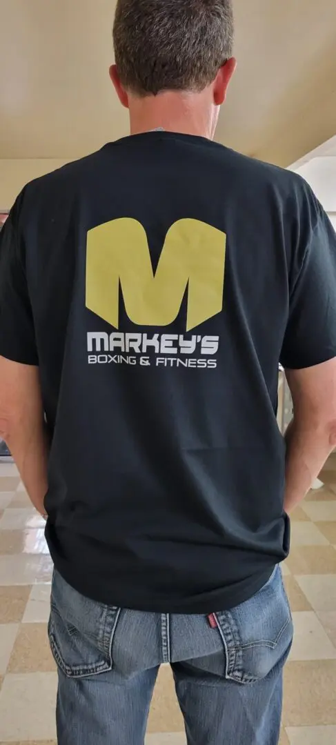 A man wearing a markeys boxing and fitness logo on it.