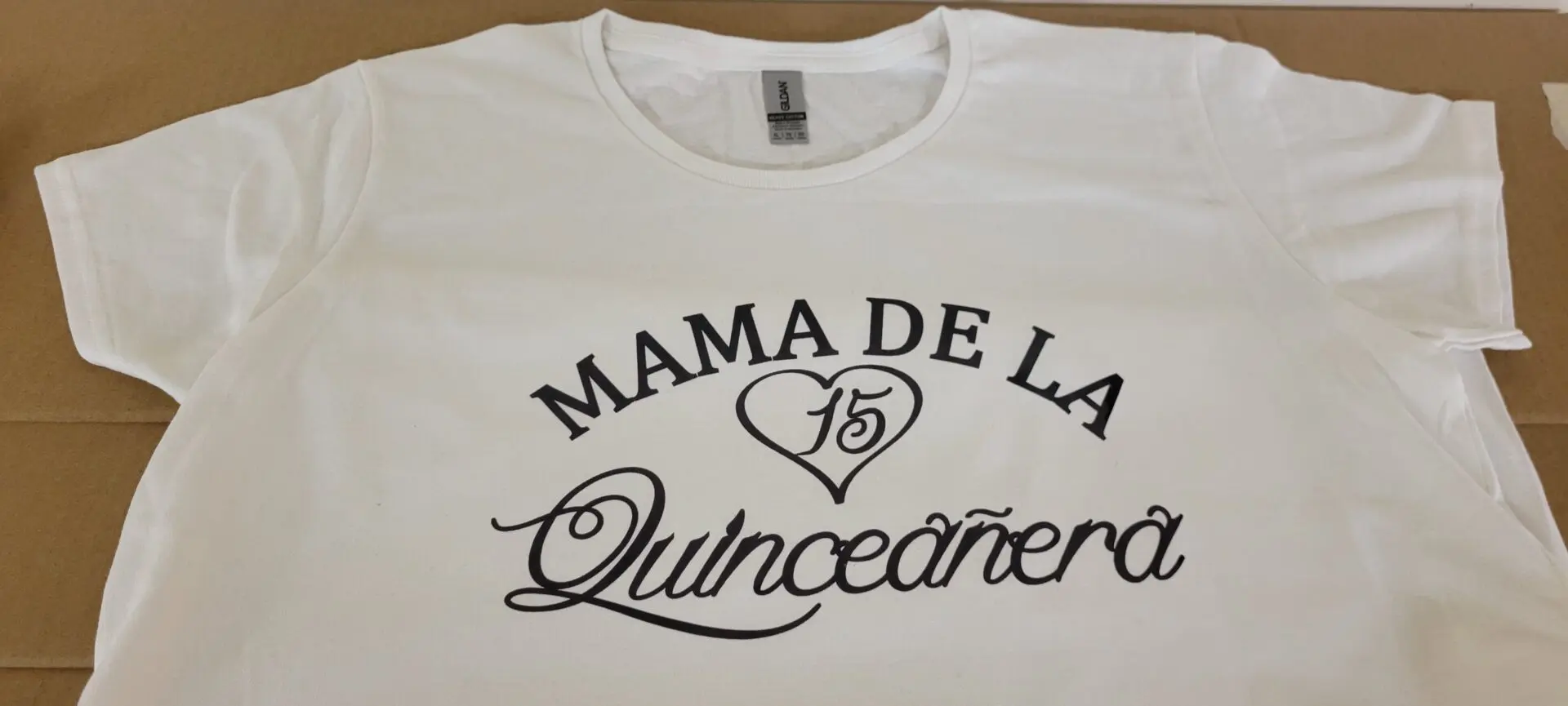 A white tshirt with the word mama de la in black