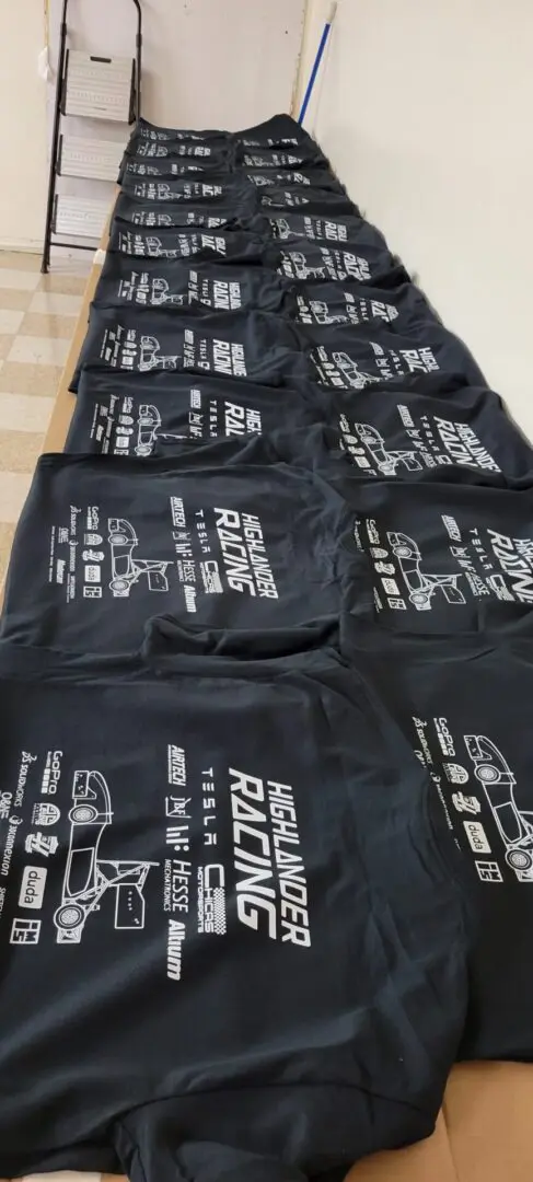 A bunch of black tshirt kept side by side on a table