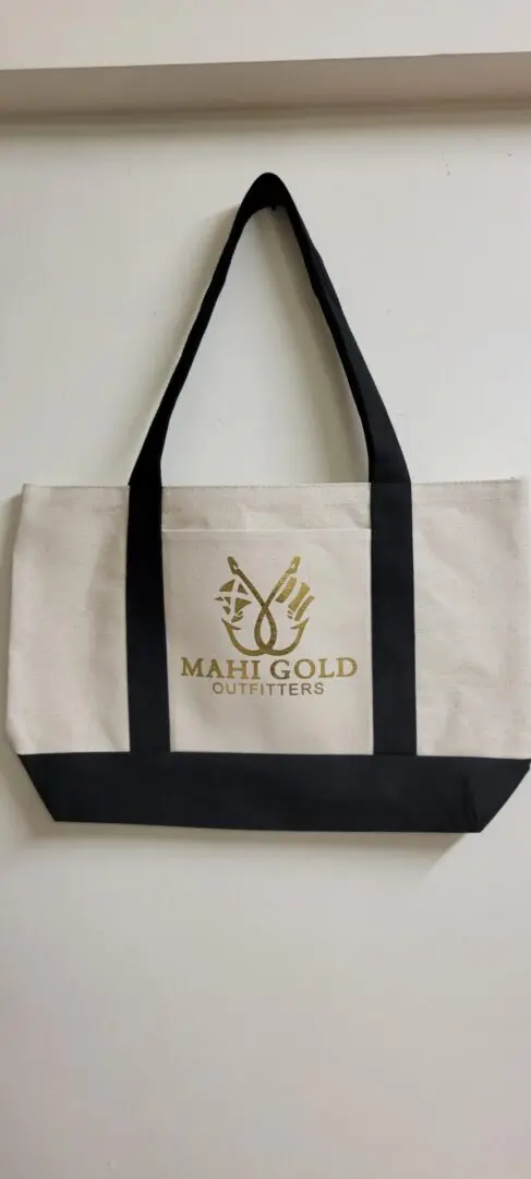 A bag of mahi gold with black straps hung on the white wall